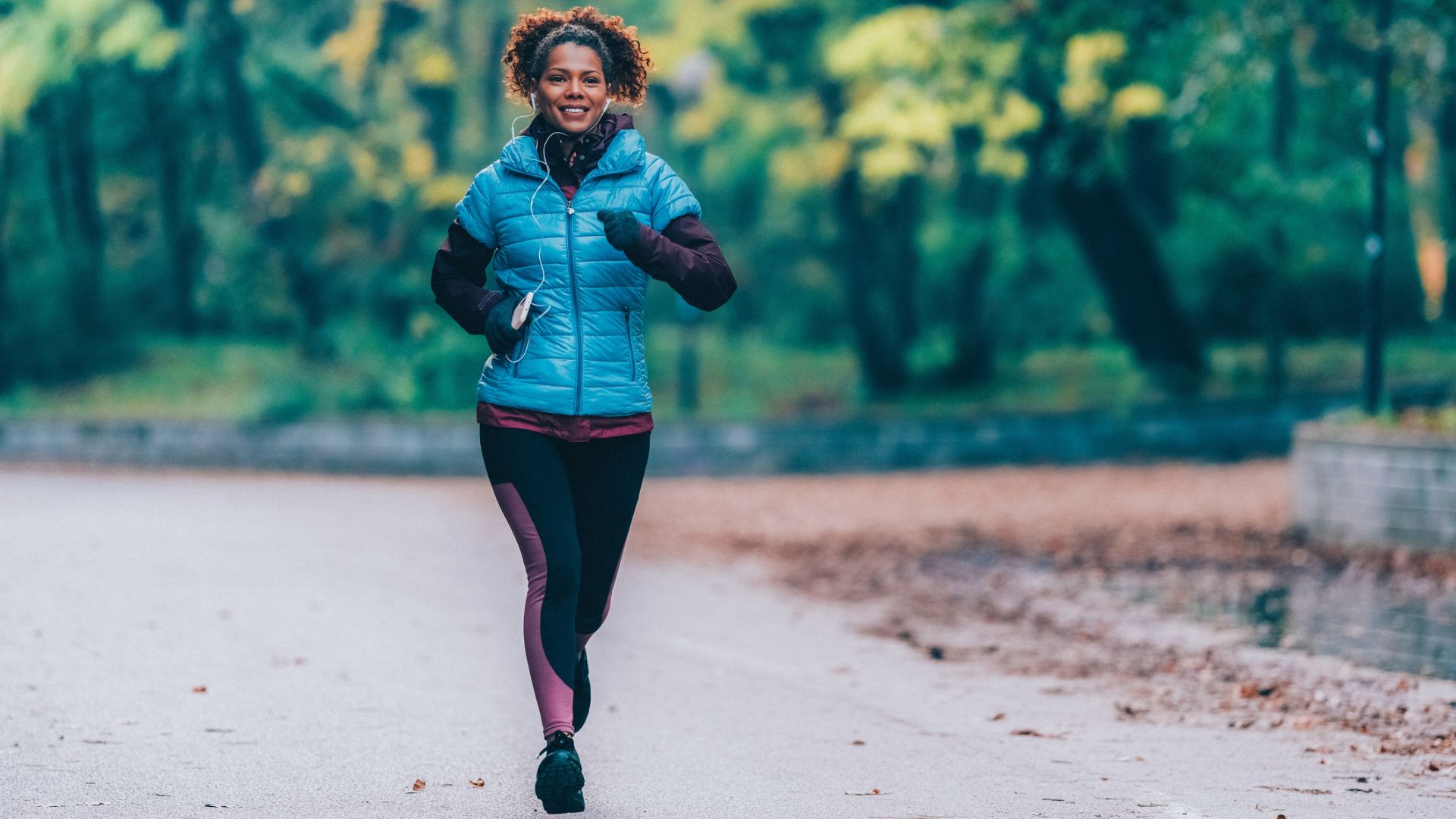 woman runs outside in an autumn / fall scene 